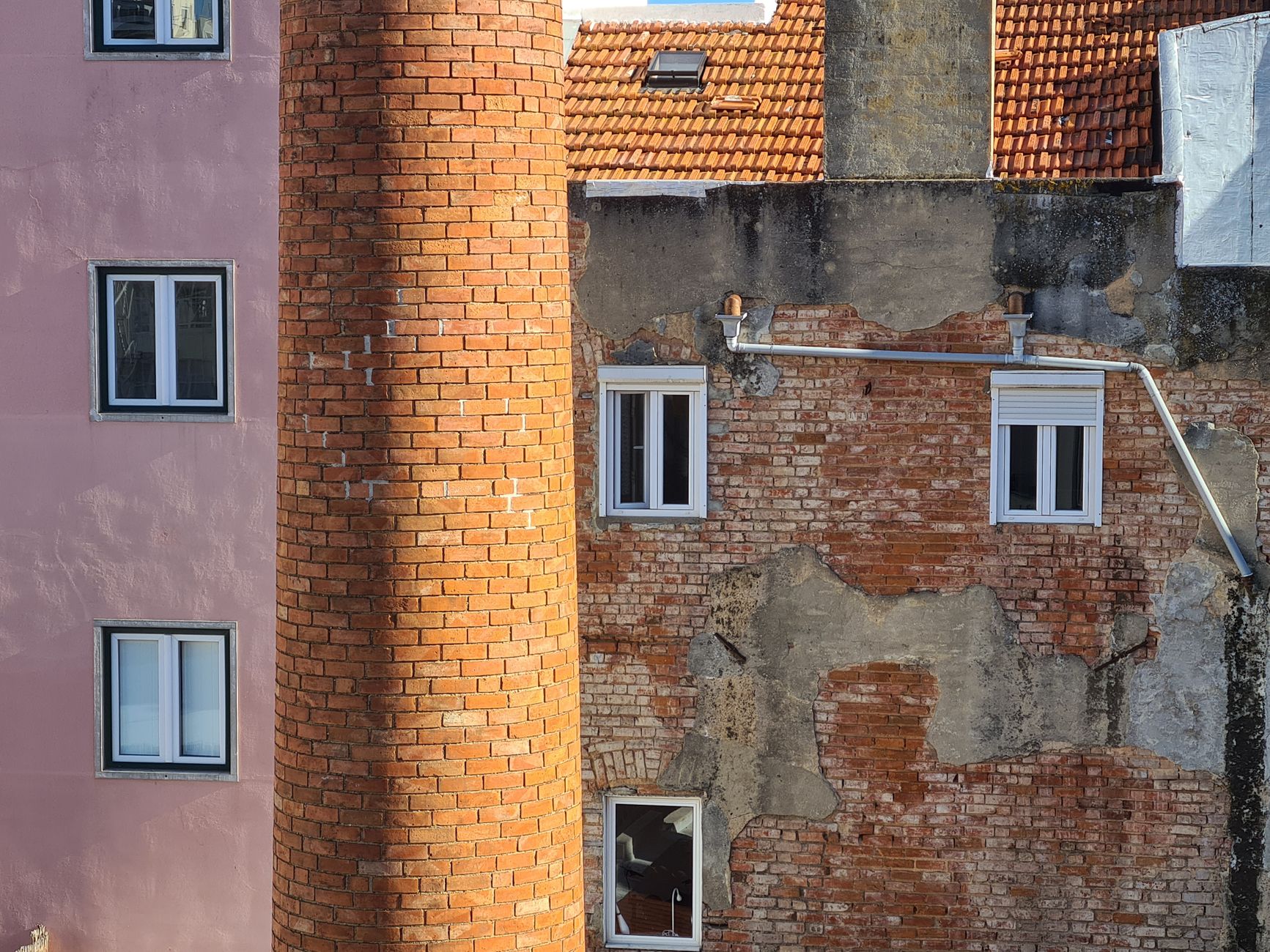 Detailed view of aging red brick and stucco walls on urban residential buildings.