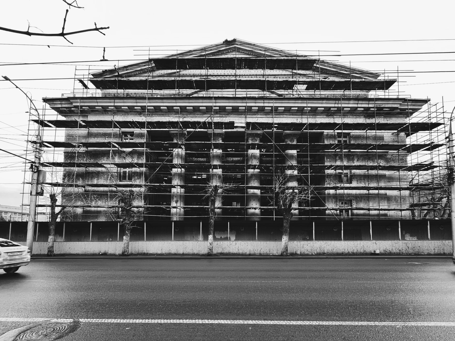 Black and white image of a neoclassical building with scaffolding in Saratov, Russia.