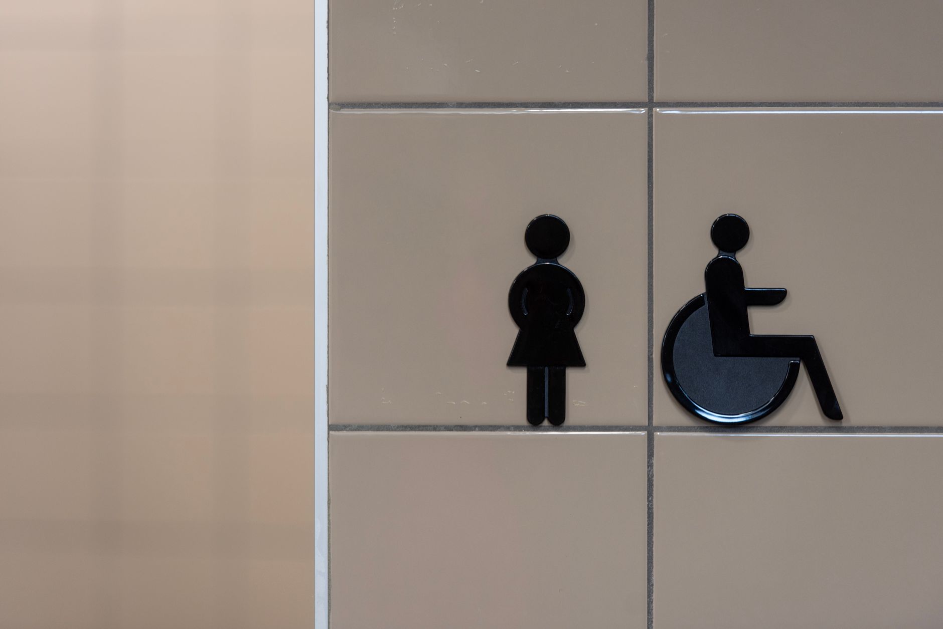 Signage showing symbols for an inclusive restroom with wheelchair accessibility.