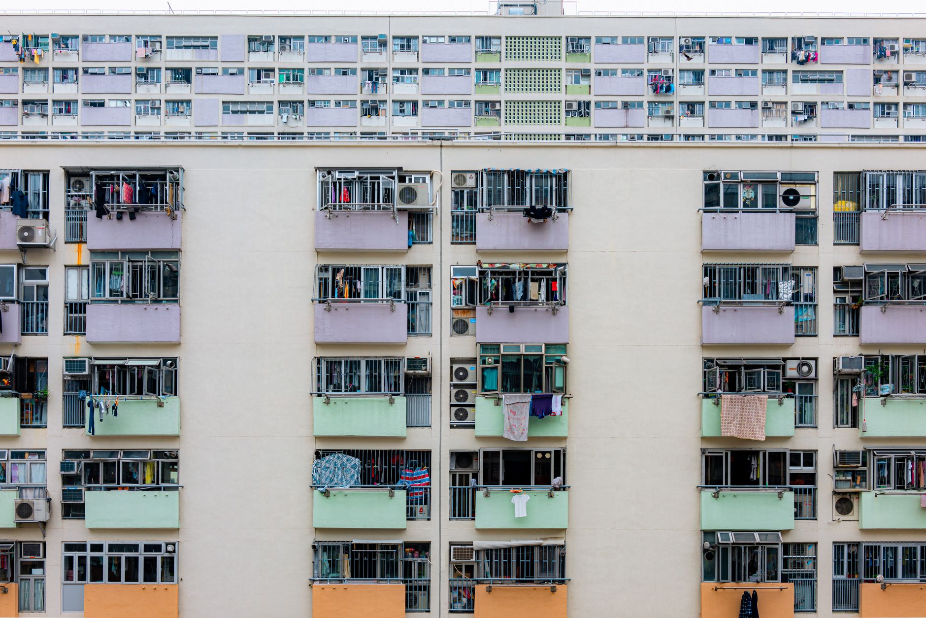 Multicolored urban apartment building with balconies and windows, showcasing city living.