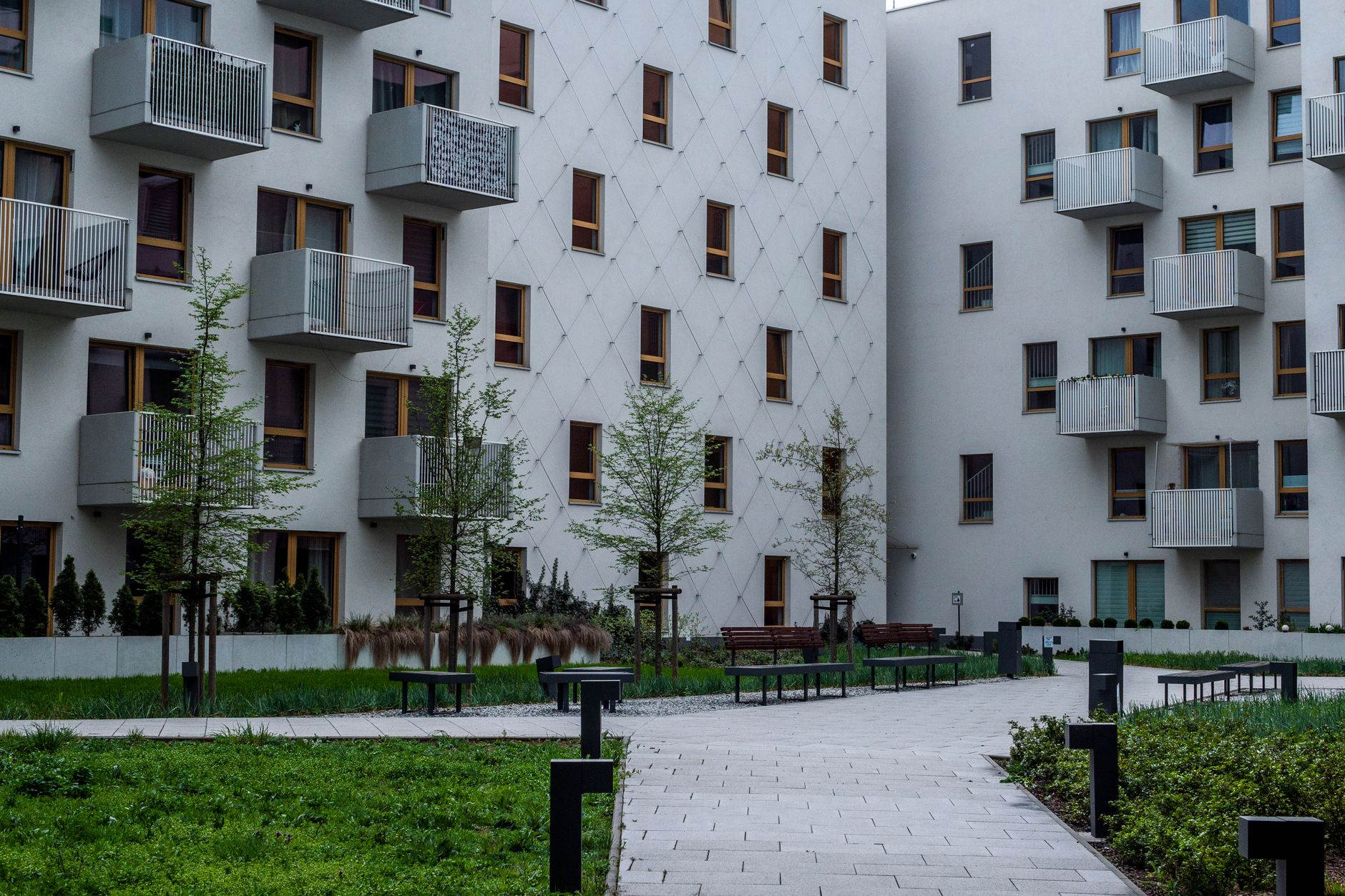 Contemporary apartment complex with landscaped courtyard and balconies.