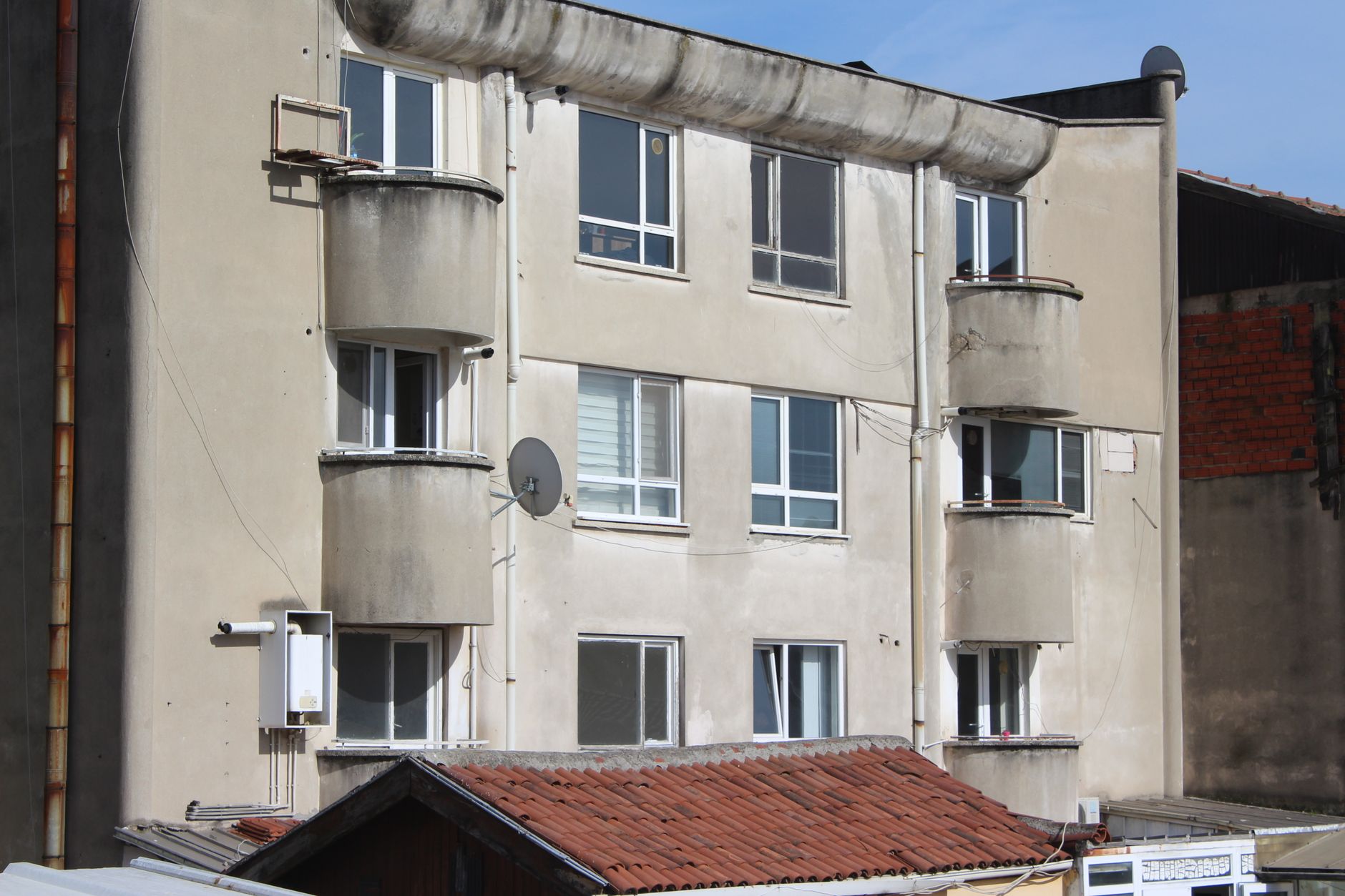 Close-up of an urban apartment building exterior with balconies and windows.