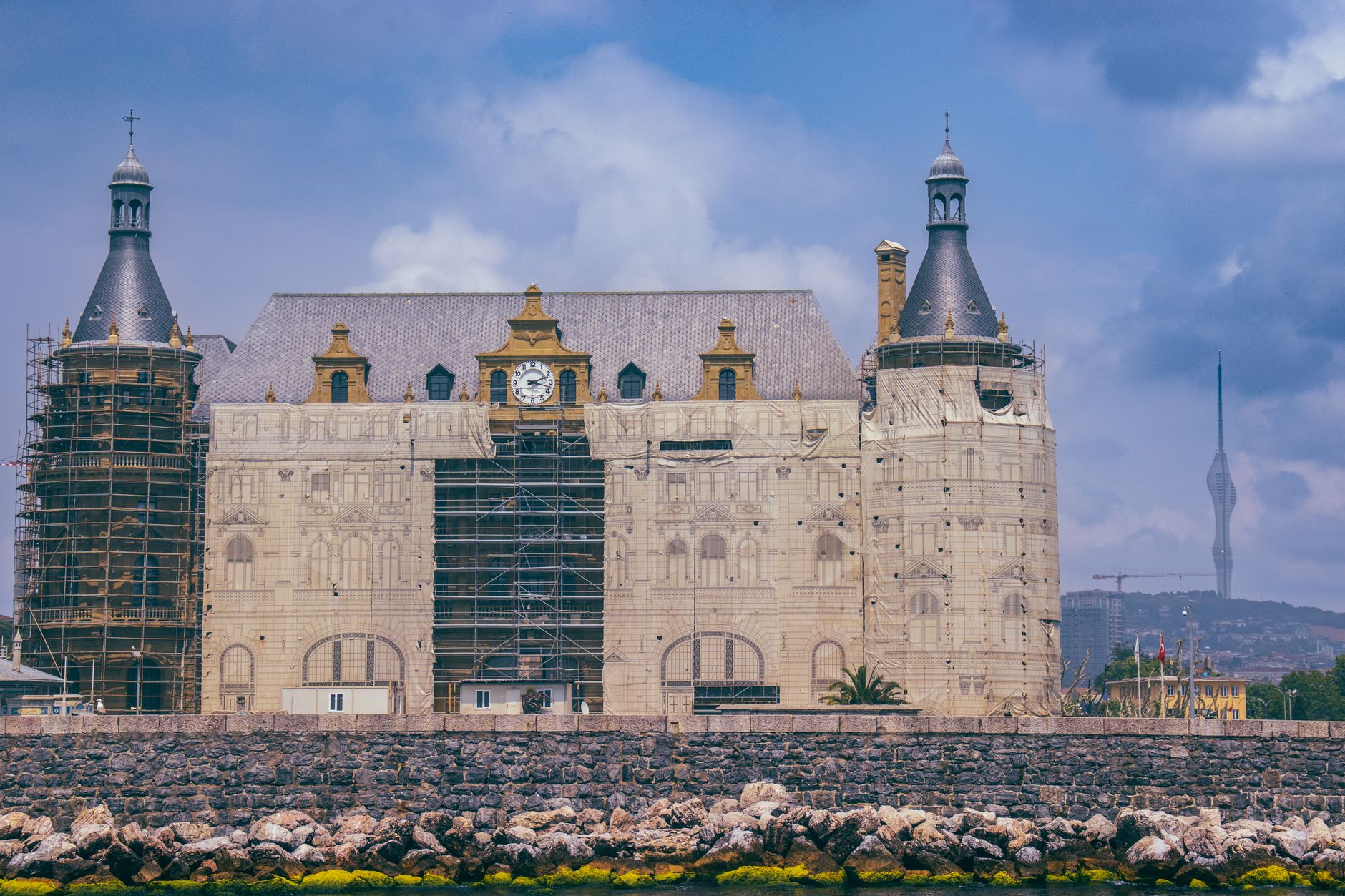 Haydarpaşa Station under renovation with scaffolding against a blue sky in Istanbul, Türkiye.