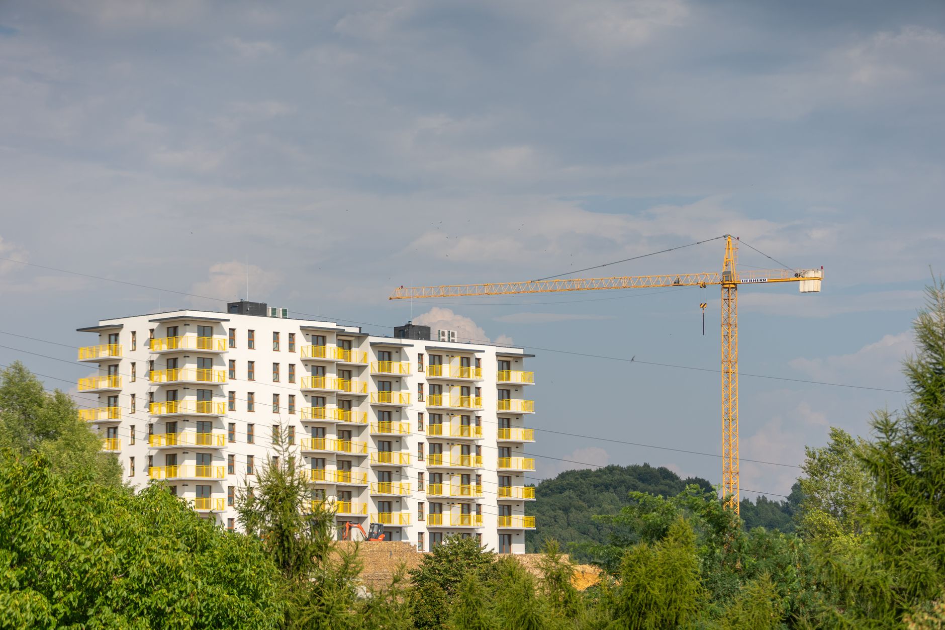 View of modern apartment building and construction crane in Trzebinia, Poland.
