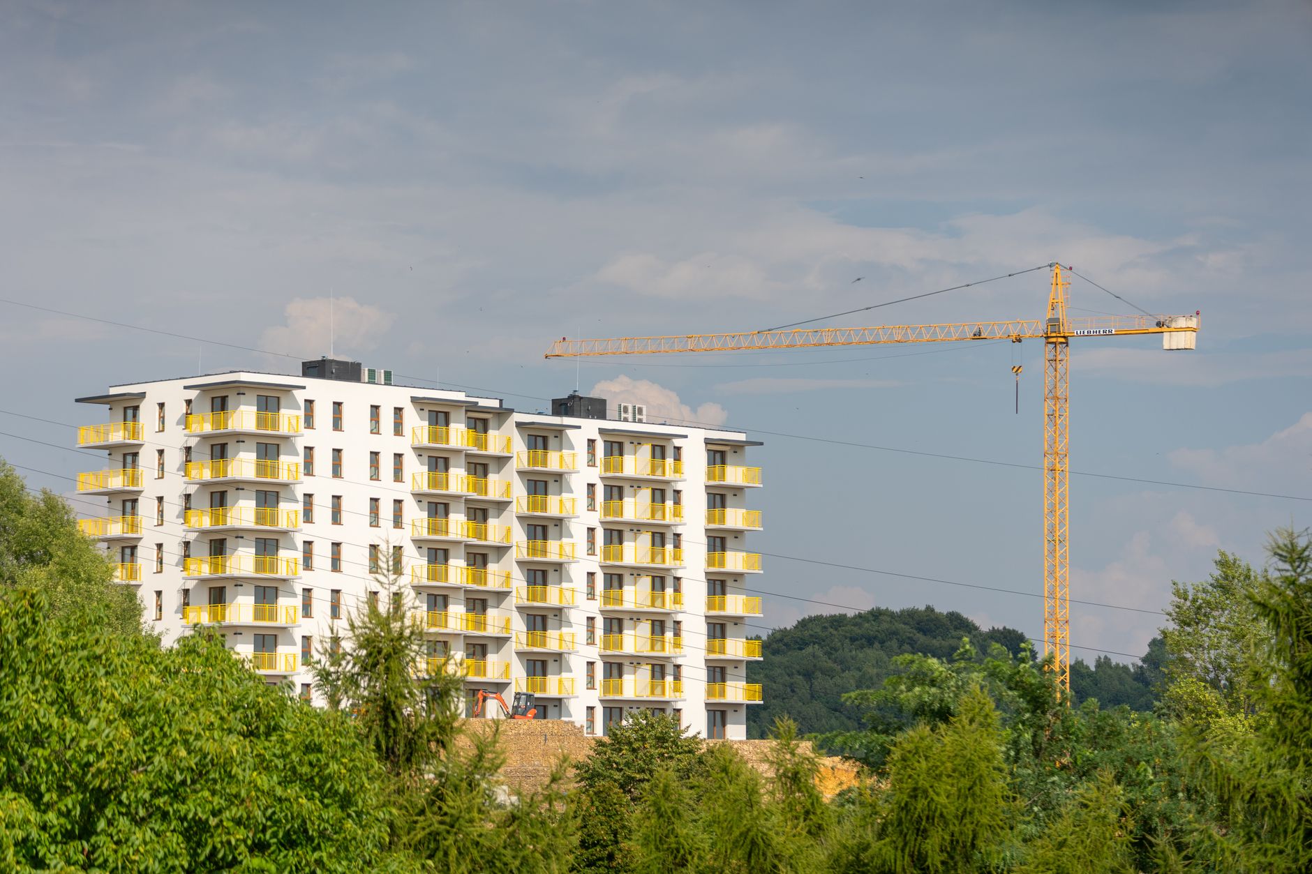 View of an apartment building under construction with a crane in Trzebinia, Poland.