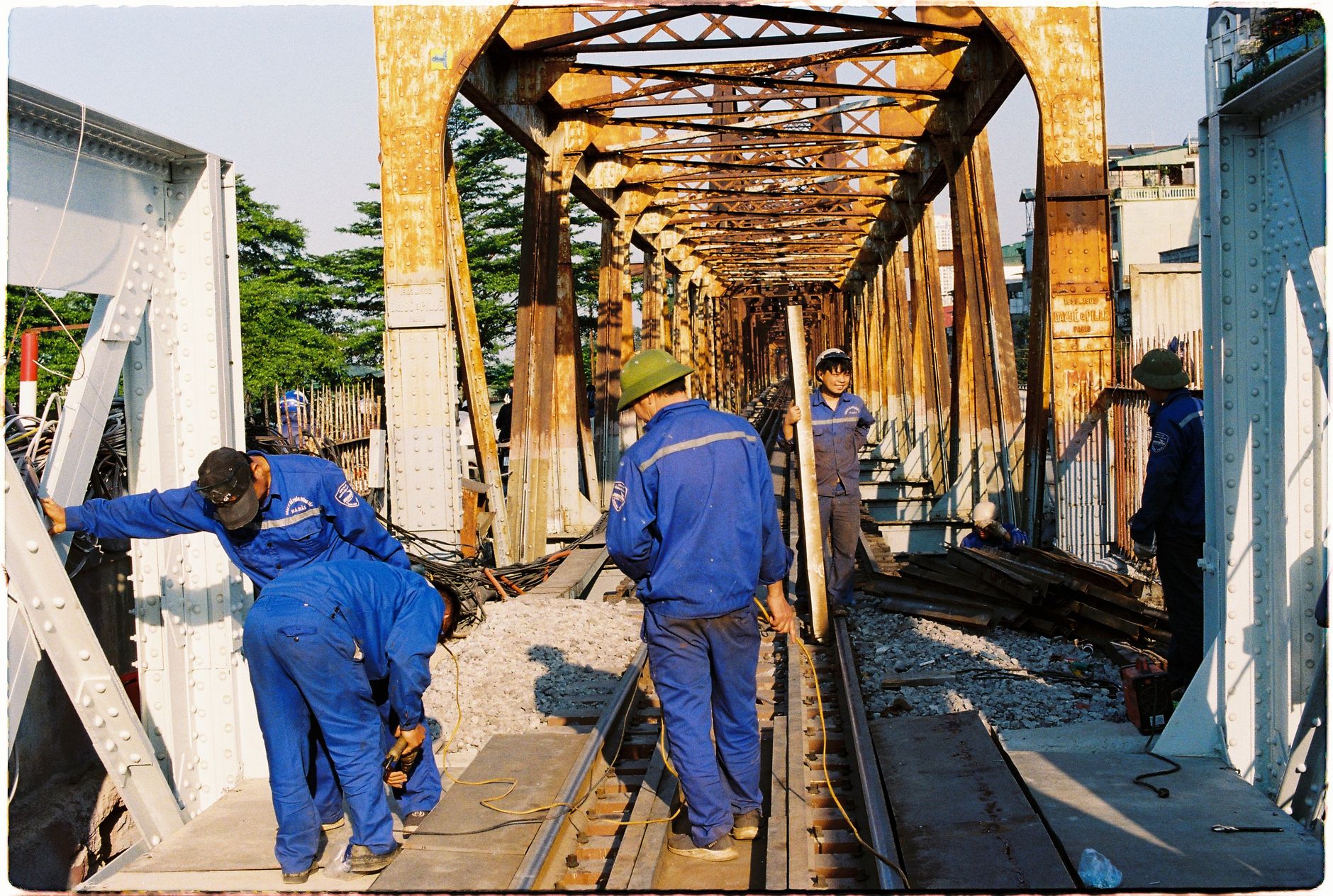 Team of workers repairing a railway bridge during the day.