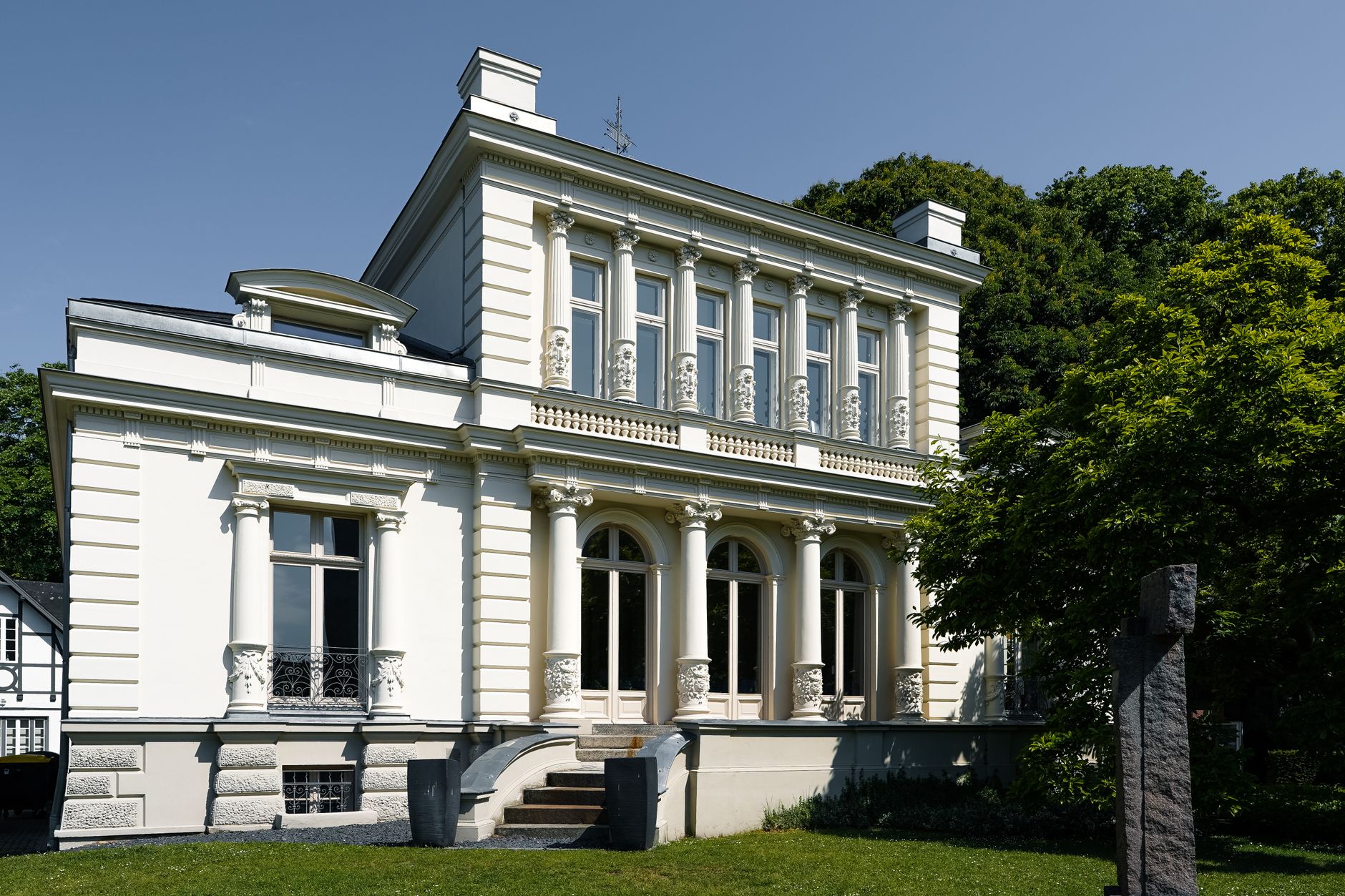 Elegant historic mansion in Elmshorn, Germany, showcasing neoclassical architecture on a sunny day.