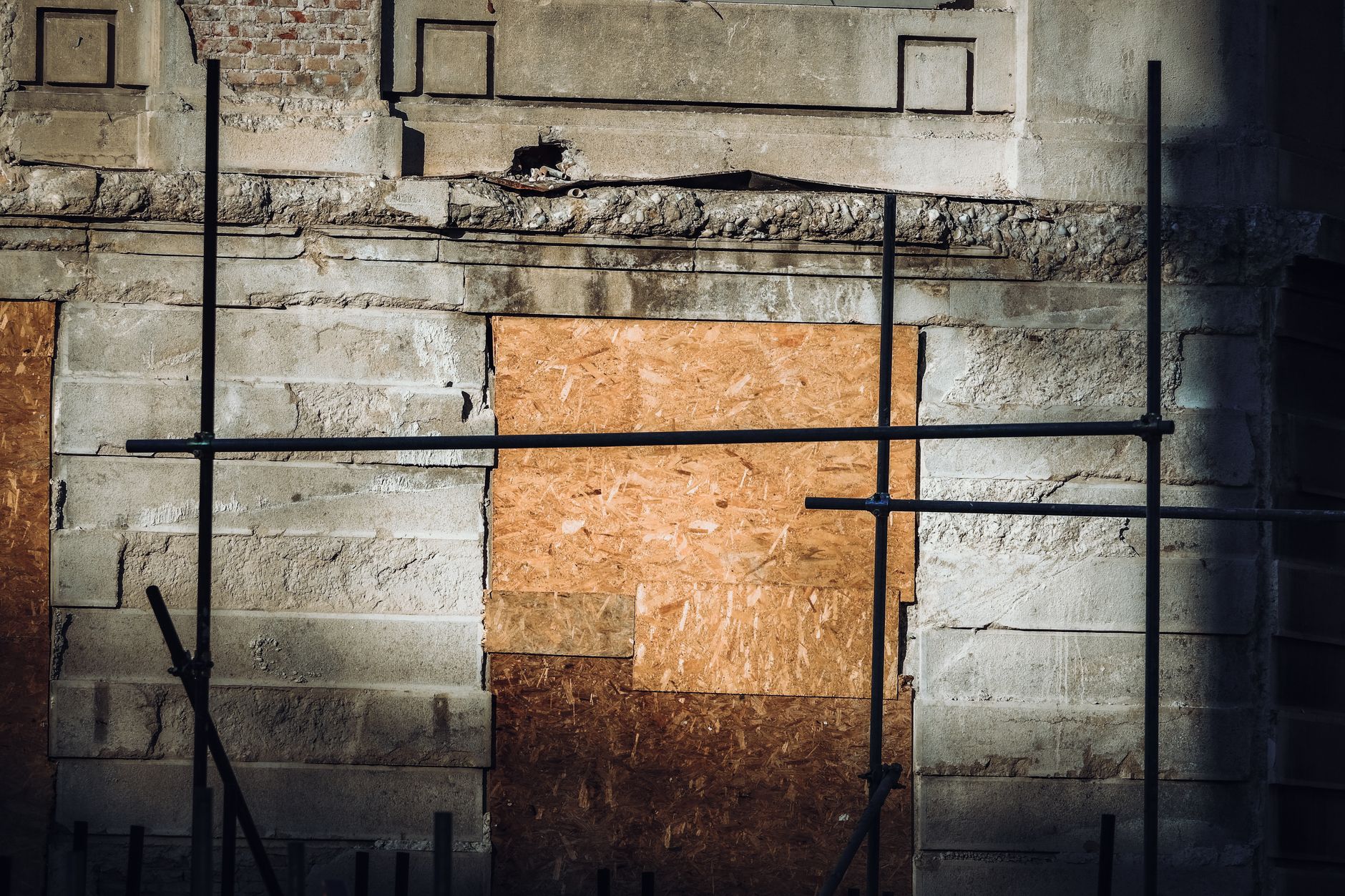 Close-up of an abandoned building facade with scaffolding for restoration.