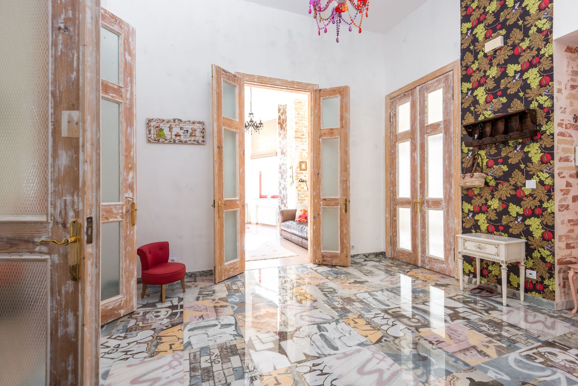 A vibrant, eclectic interior featuring colorful floors, wooden doors, and vivid wallpaper.